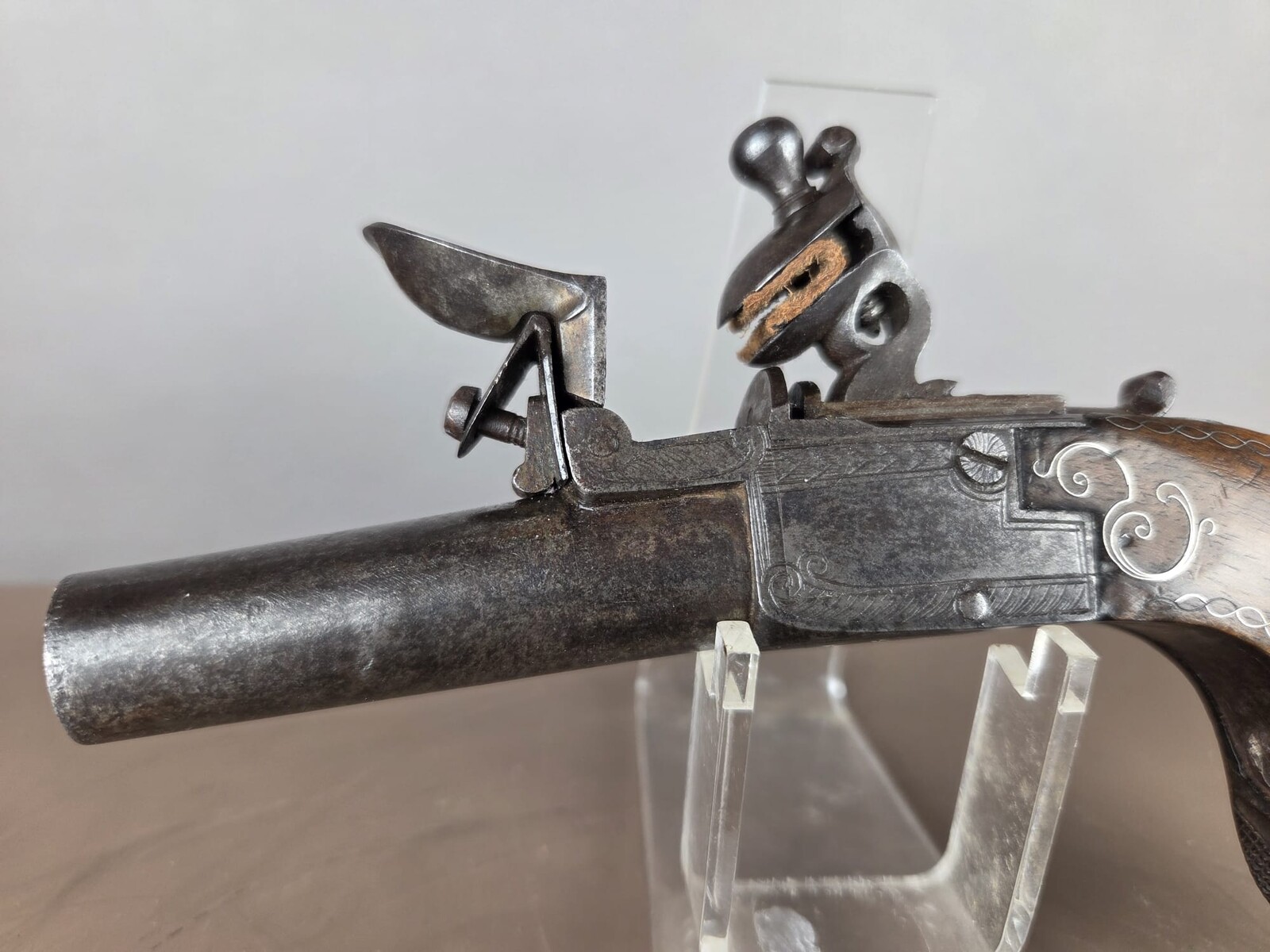 Small flintlock pistol with a box-shaped stock, silver threads in the grip, France, circa 1800