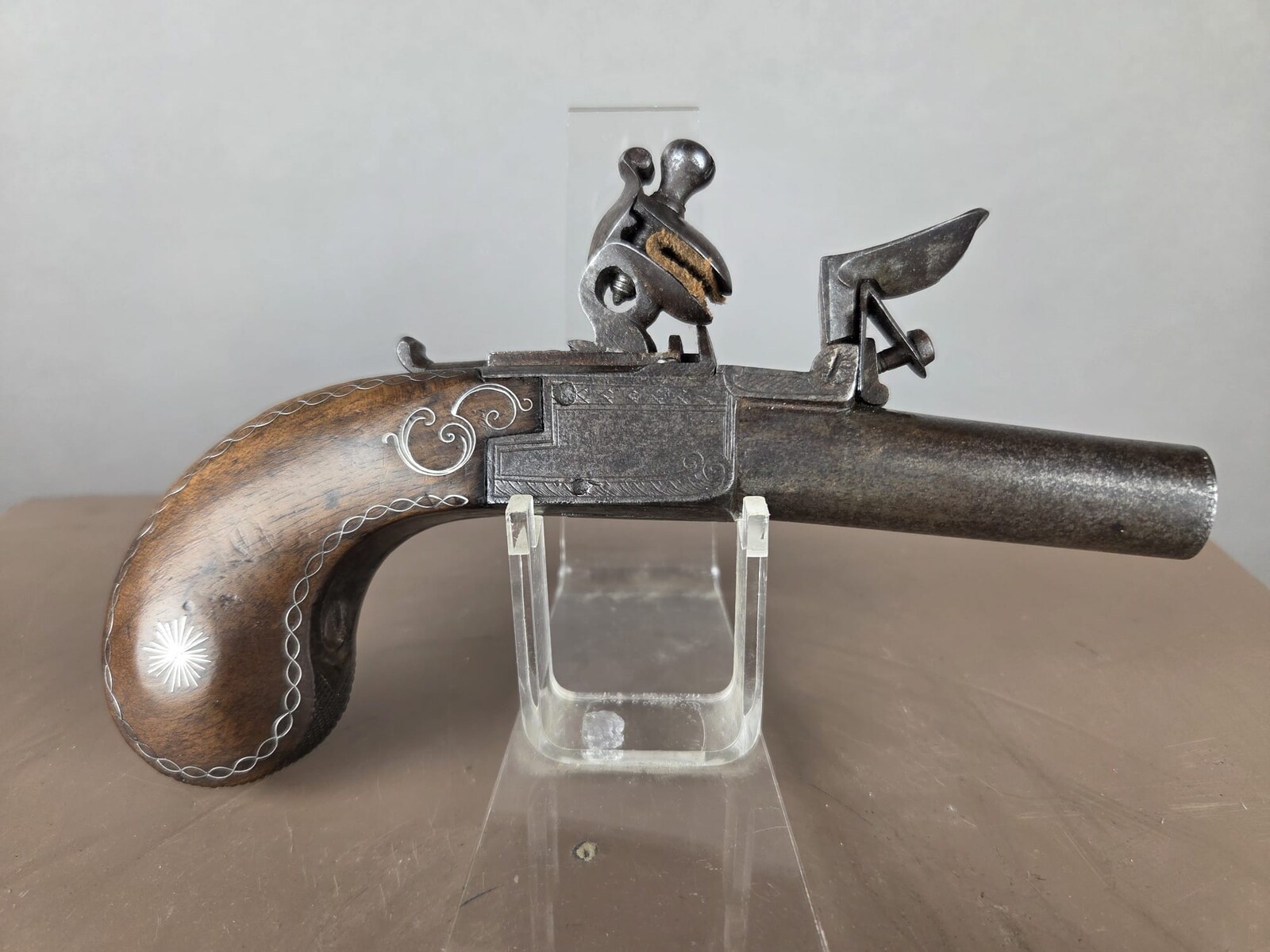 Small flintlock pistol with a box-shaped stock, silver threads in the grip, France, circa 1800
