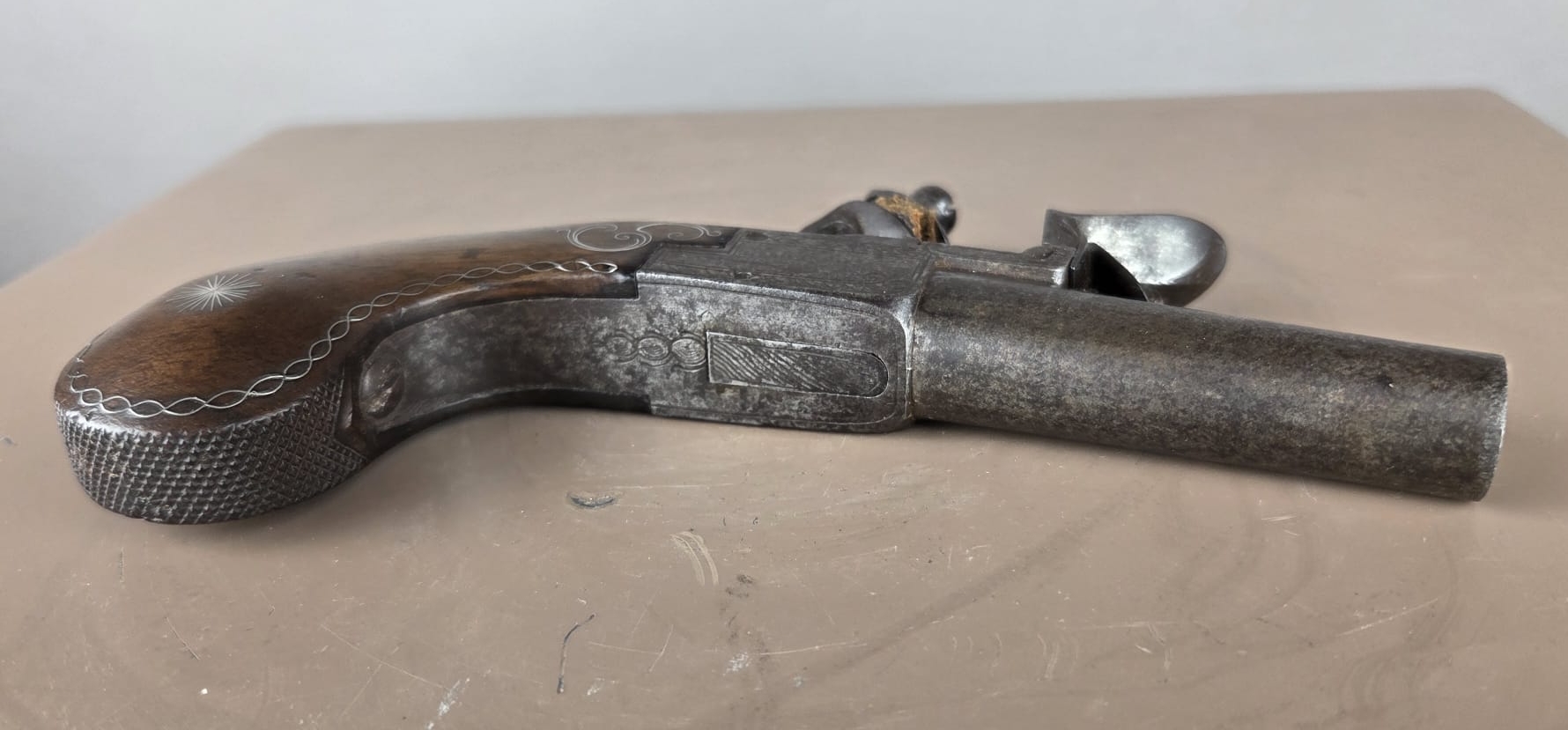 Small flintlock pistol with a box-shaped stock, silver threads in the grip, France, circa 1800