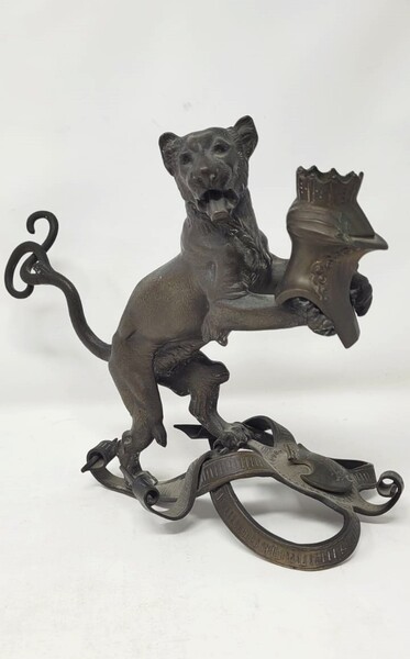 Bronze candlestick with black patina representing a young lion wearing a helm