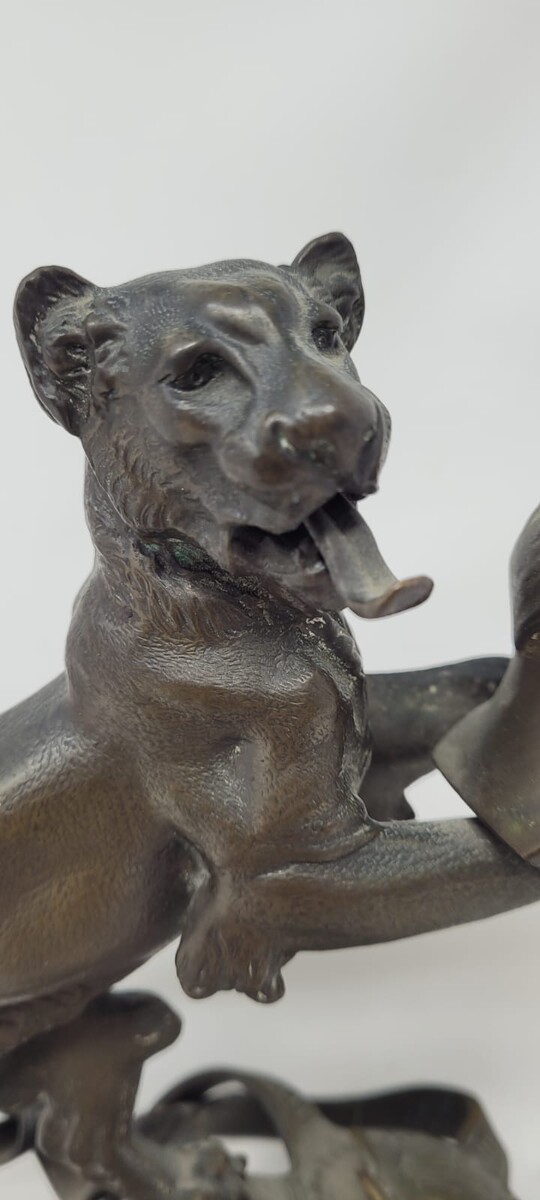 Bronze candlestick with black patina representing a young lion wearing a helm