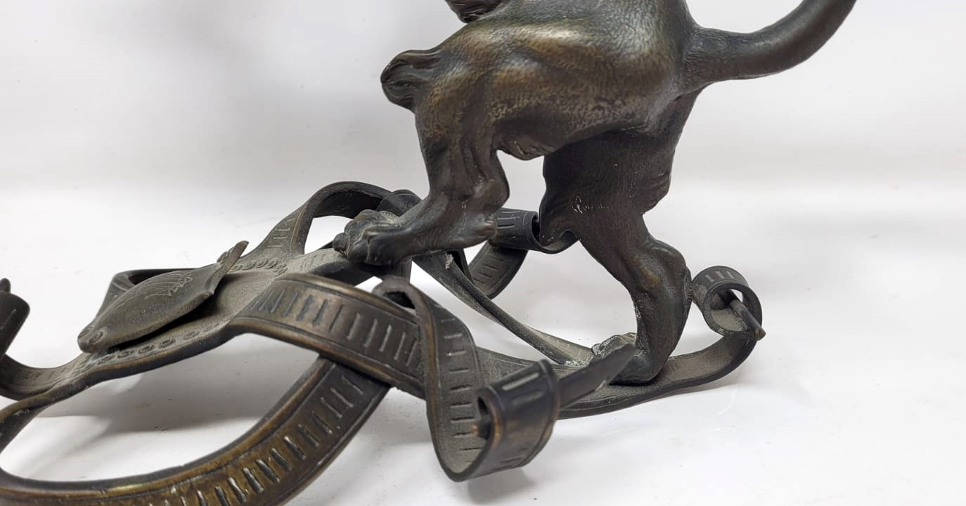 Bronze candlestick with black patina representing a young lion wearing a helm