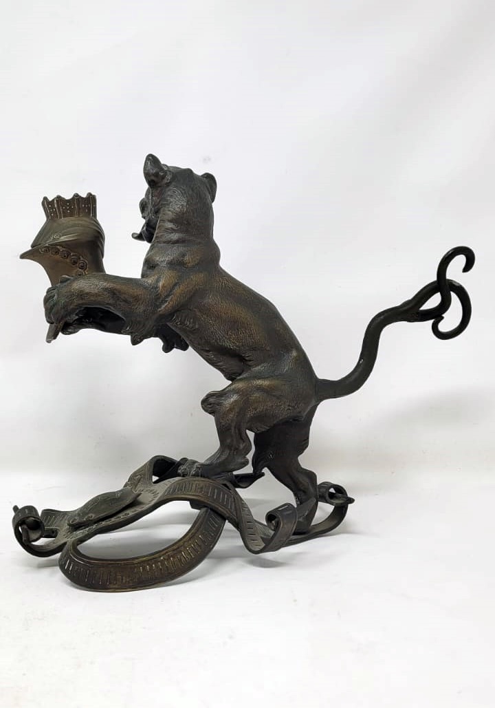 Bronze candlestick with black patina representing a young lion wearing a helm