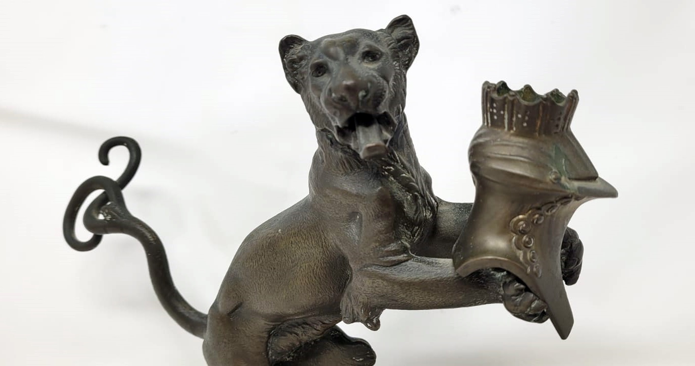 Bronze candlestick with black patina representing a young lion wearing a helm