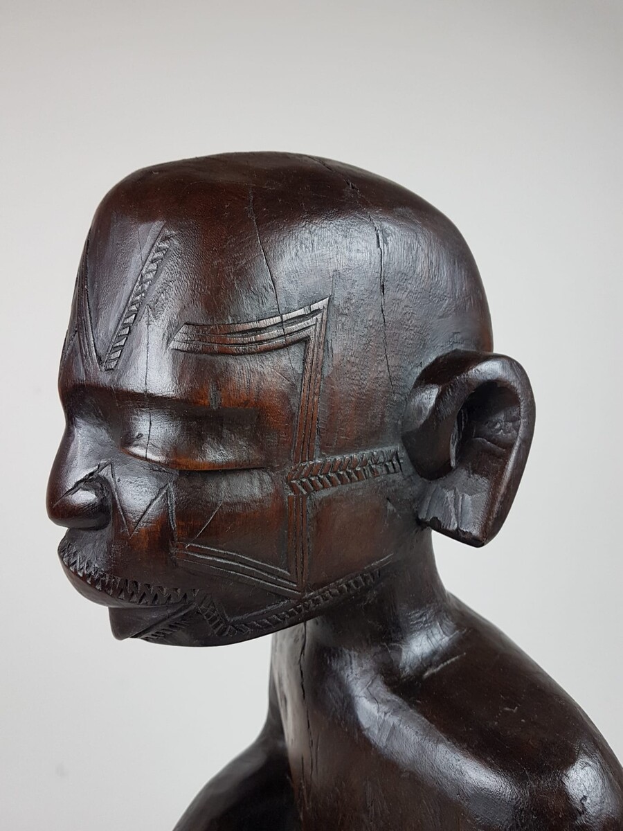 MaKonde seated statue - Statue embodying an ancestor, composed of incised scarifications in the wood and thick protruding lips specific to Makonde statuary Tanzania, northern Mozambique