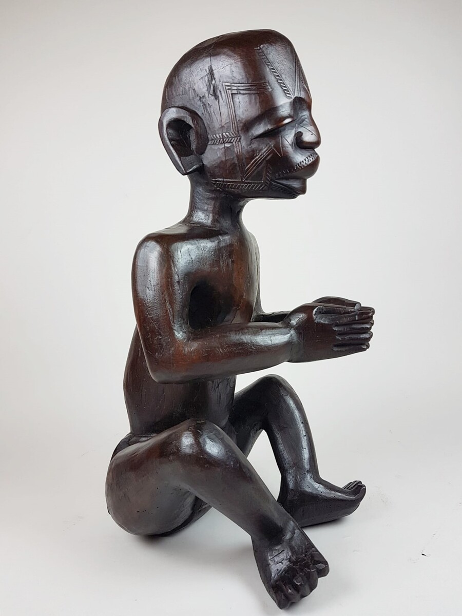 MaKonde seated statue - Statue embodying an ancestor, composed of incised scarifications in the wood and thick protruding lips specific to Makonde statuary Tanzania, northern Mozambique