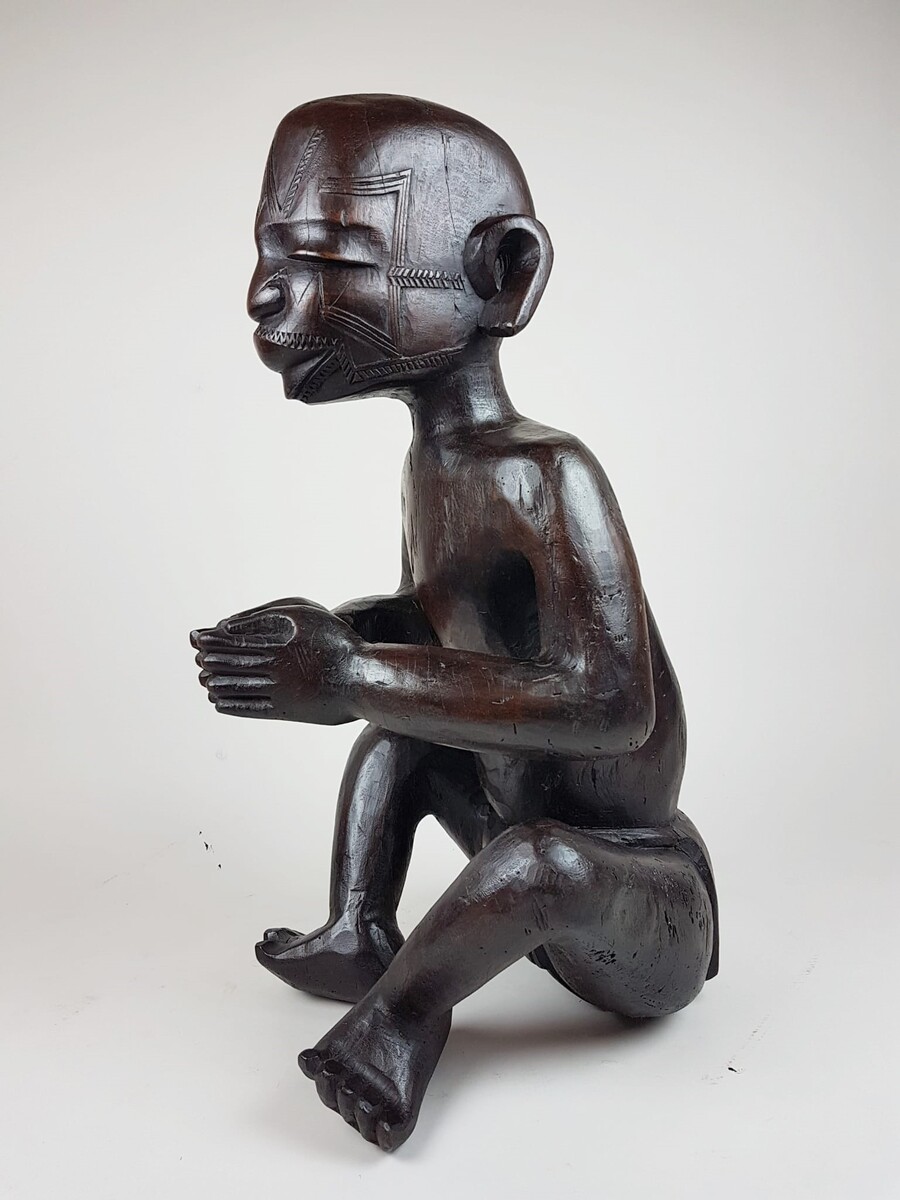 MaKonde seated statue - Statue embodying an ancestor, composed of incised scarifications in the wood and thick protruding lips specific to Makonde statuary Tanzania, northern Mozambique