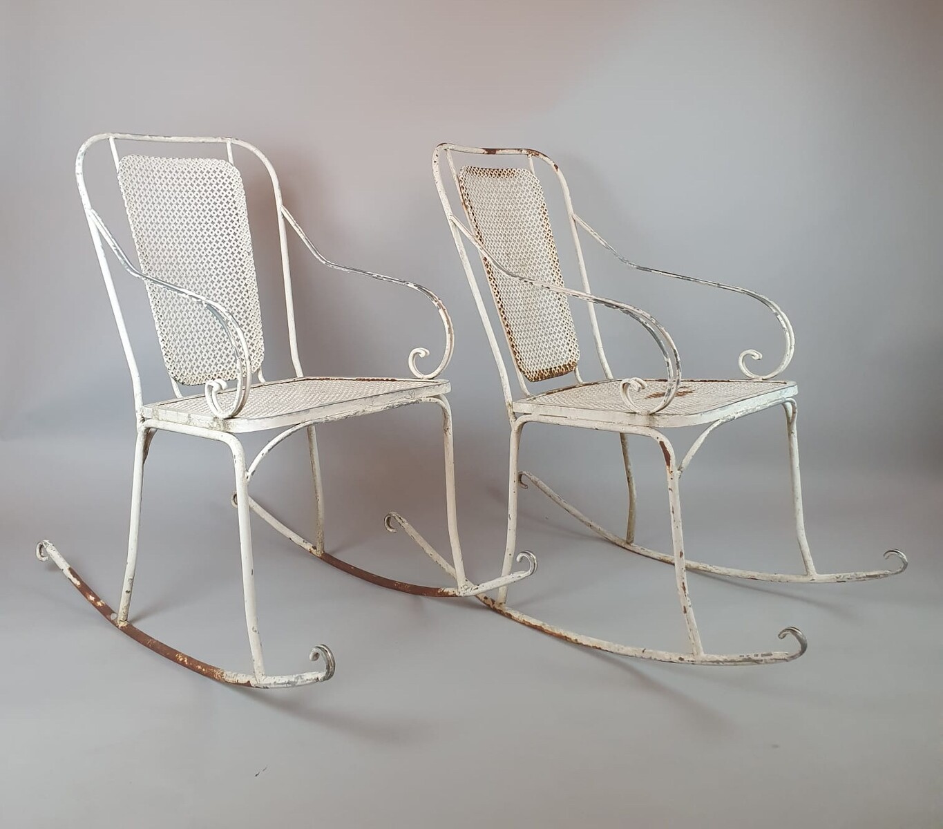 Pair of wrought iron and perforated metal rocking chairs, circa 1960