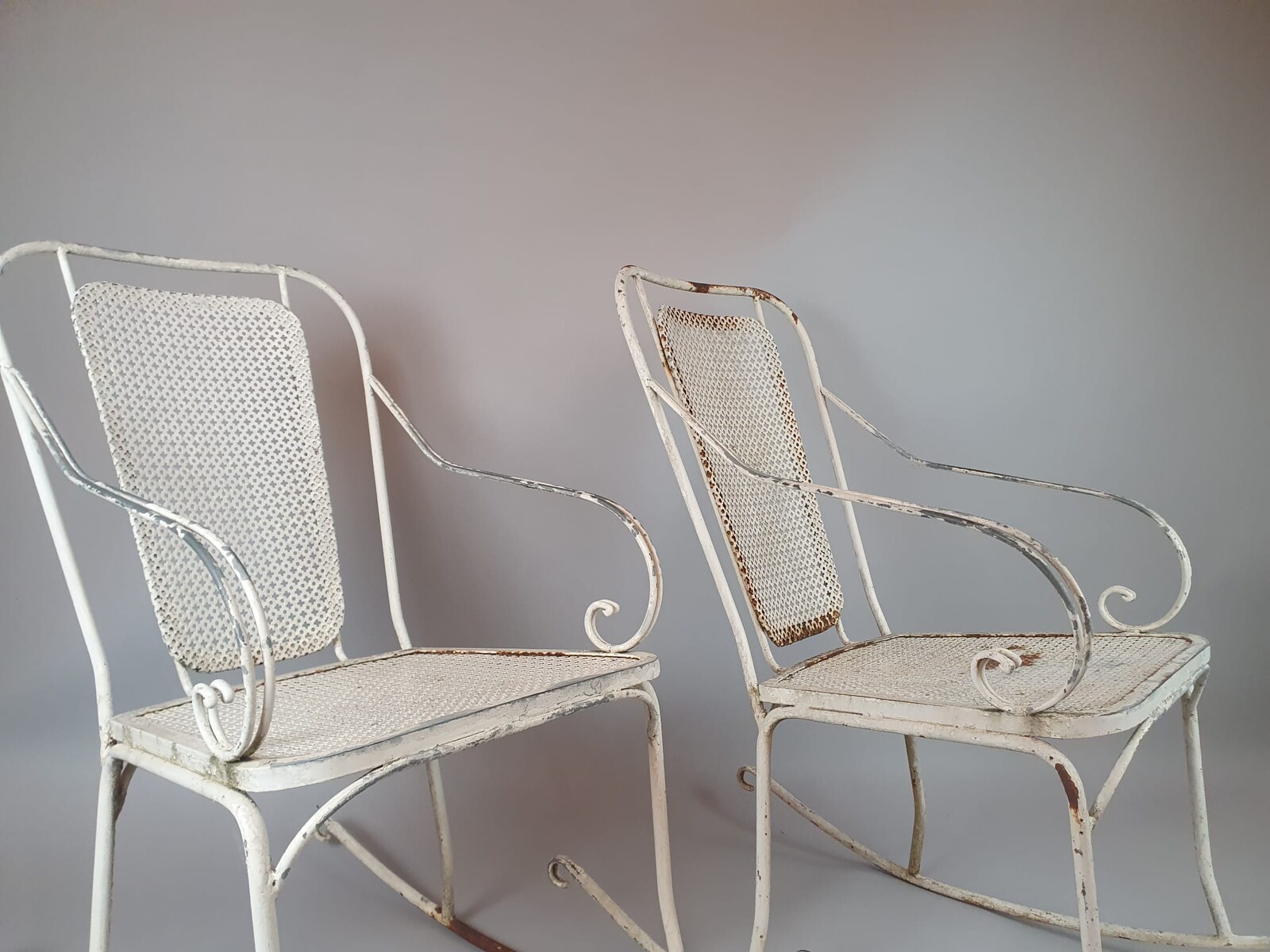 Pair of wrought iron and perforated metal rocking chairs, circa 1960
