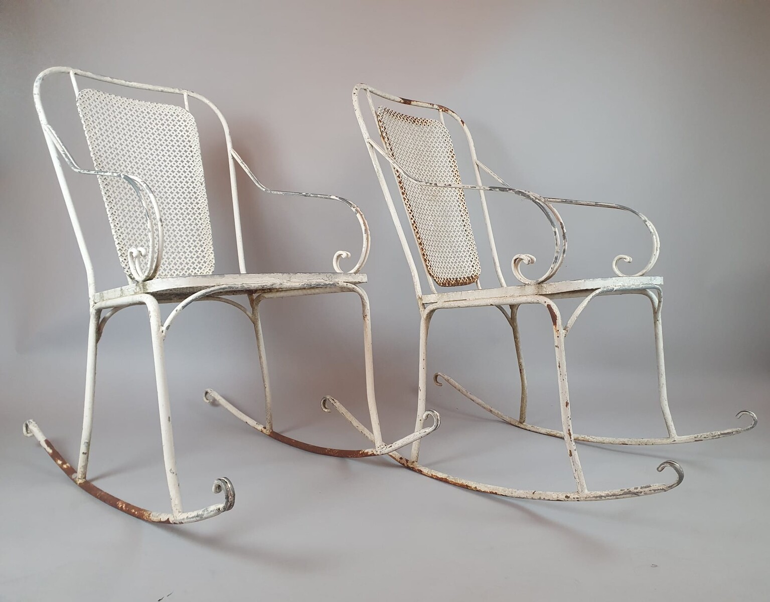 Pair of wrought iron and perforated metal rocking chairs, circa 1960