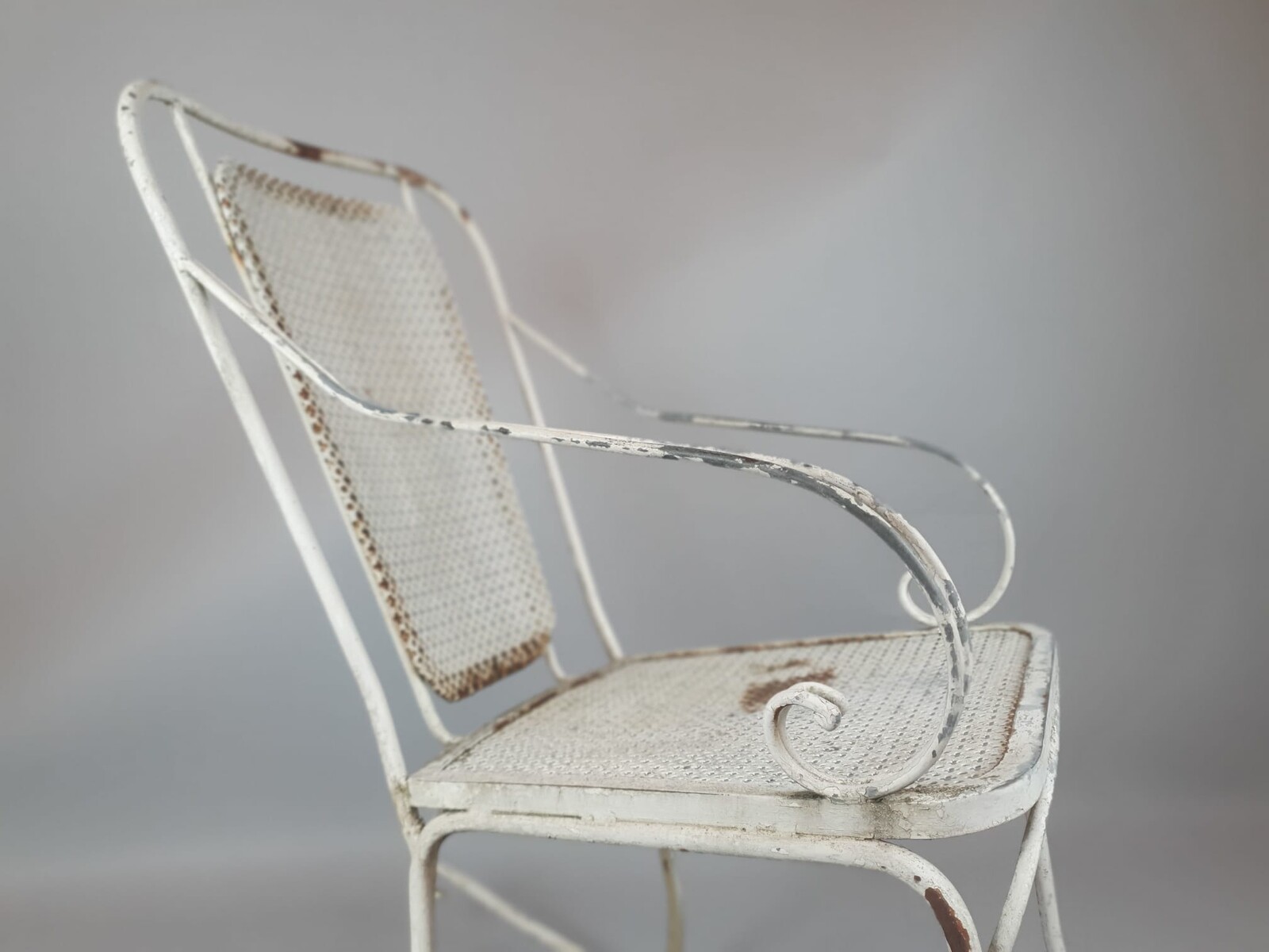 Pair of wrought iron and perforated metal rocking chairs, circa 1960