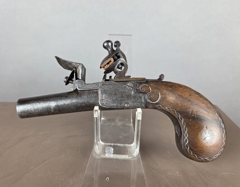 Small flintlock pistol with a box-shaped stock, silver threads in the grip, France, circa 1800